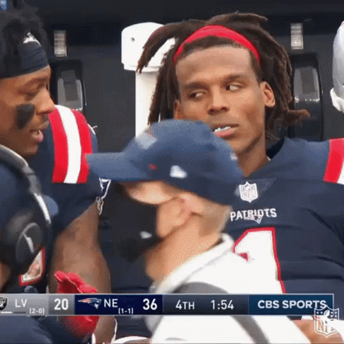 Football player in Patriots uniform reacting with frustration and covering his face.