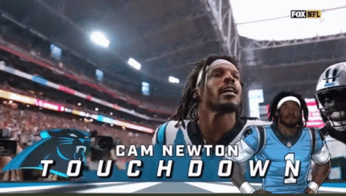 Football player celebrating touchdown, arms raised, then turns and walks away.