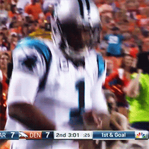 Football player number 1 fumbles the ball during a game with teammates and opponents around him.