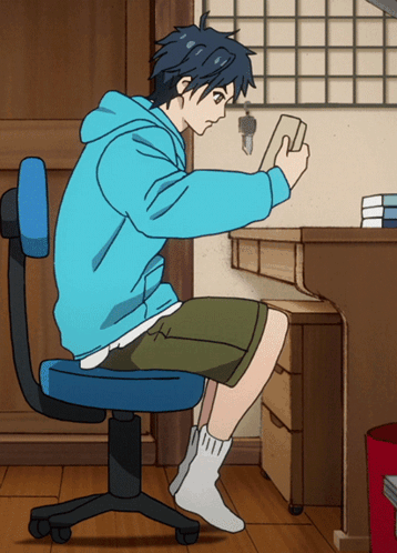 Anime boy sitting at desk studying with book