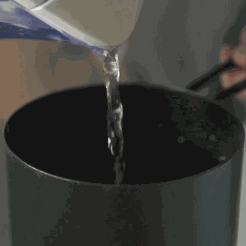 Pouring Water Into The Pot Two Plaid Aprons GIF