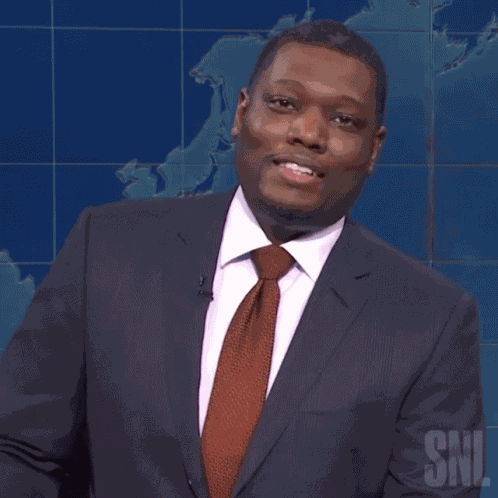 Snickering Michael Che GIF
